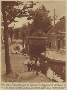 874060 Afbeelding van enkele jongetjes die met een schepnetje aan het vissen zijn bij het sluisje in het Zwarte Water ...